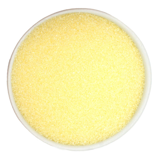 Pastel yellow sanding sugar in a tub, delicate lemon-colored crystals for spring and Easter desserts.