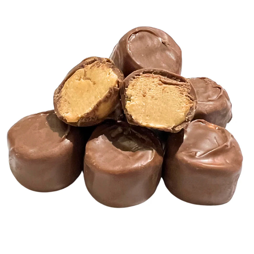 Stack of peanut butter-filled chocolate candies, with two cut open to show the creamy peanut butter center.