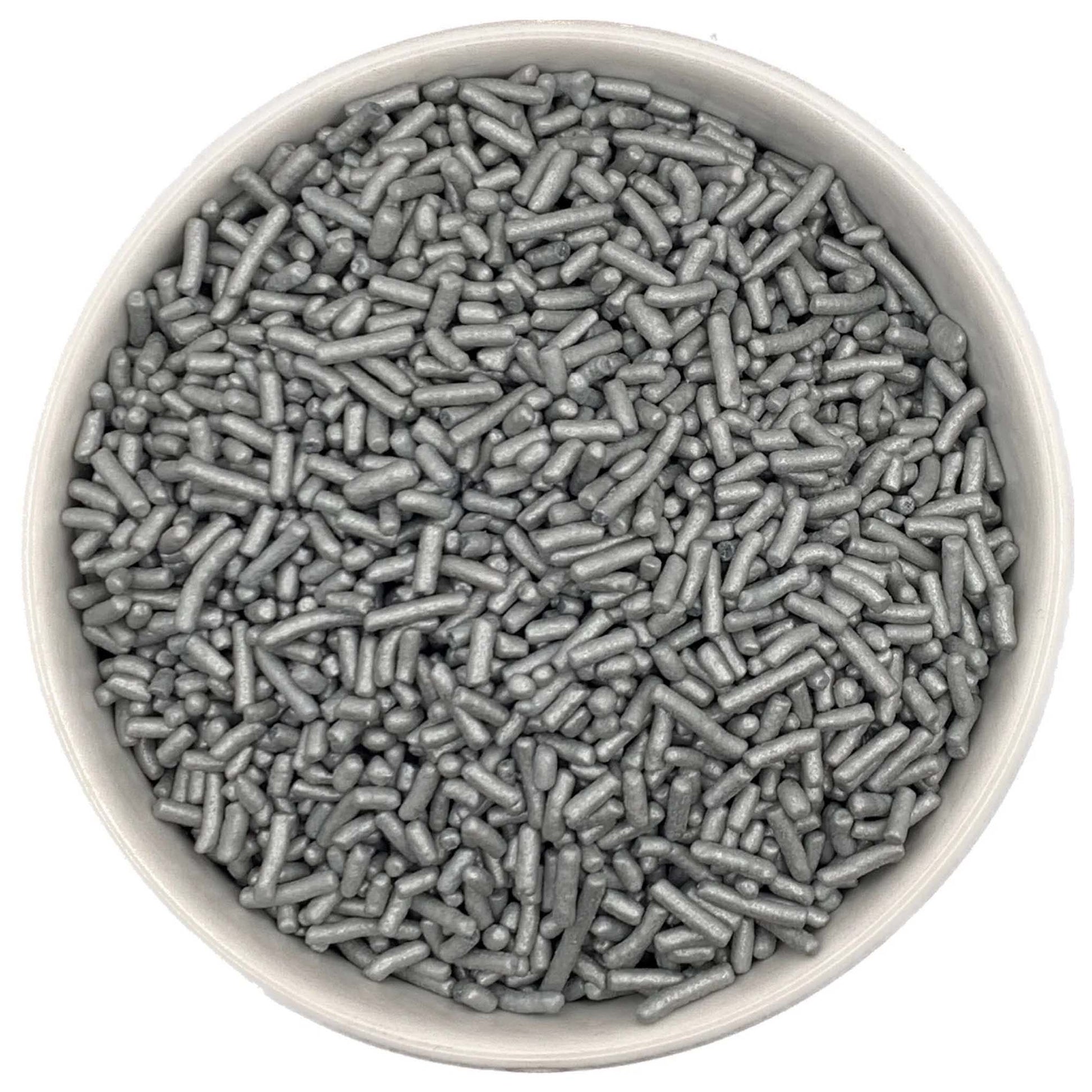 Top-down close-up of a white round container filled with pearlized silver jimmies sprinkles, showing metallic sheen on small rod-shaped pieces.