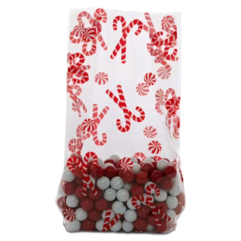 Clear cellophane treat bag printed with red candy canes and peppermint swirl candies, shown filled with red and white round candies and standing upright.