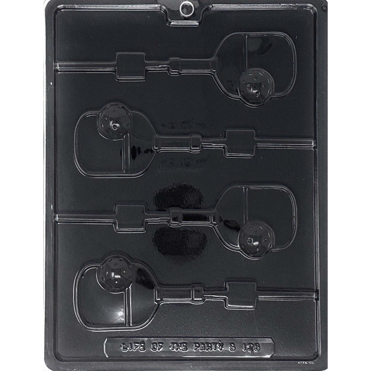 Clear Pickleball Chocolate Lollipop Mold photographed against a black background, featuring four paddle-shaped cavities with raised perforated pickleballs and lollipop stick channels.