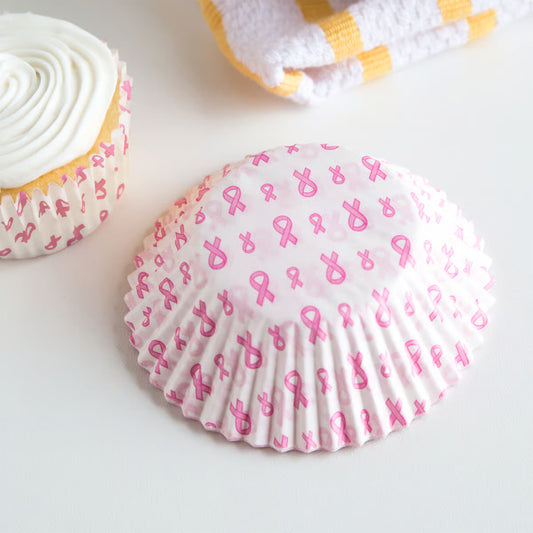 Pink ribbon cupcake liner shown with a baked cupcake and a stack of liners, awareness baking supplies