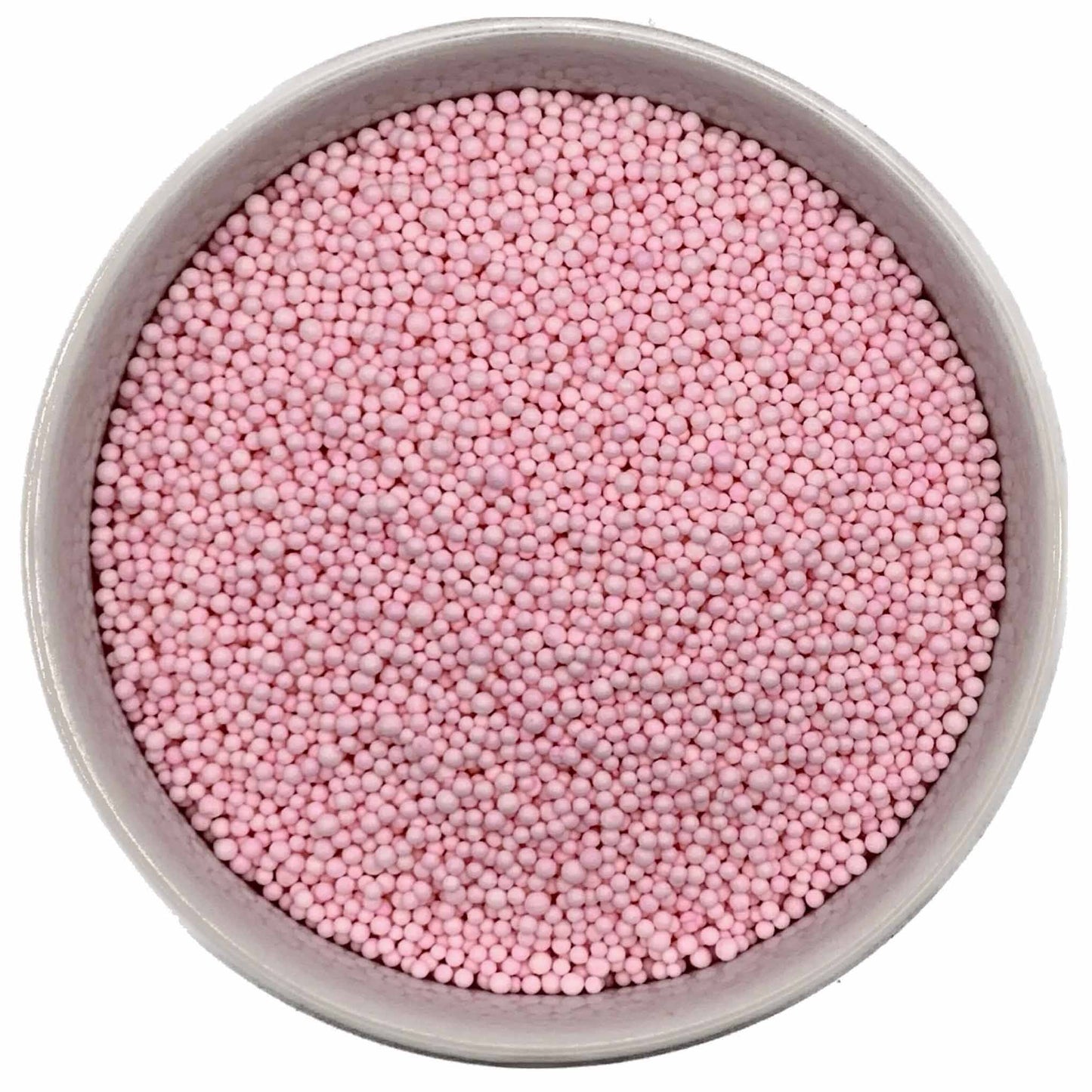 Top-down view of a round container filled with tiny pastel pink nonpareil sprinkles, showing small bead-shaped candy pieces tightly packed together.