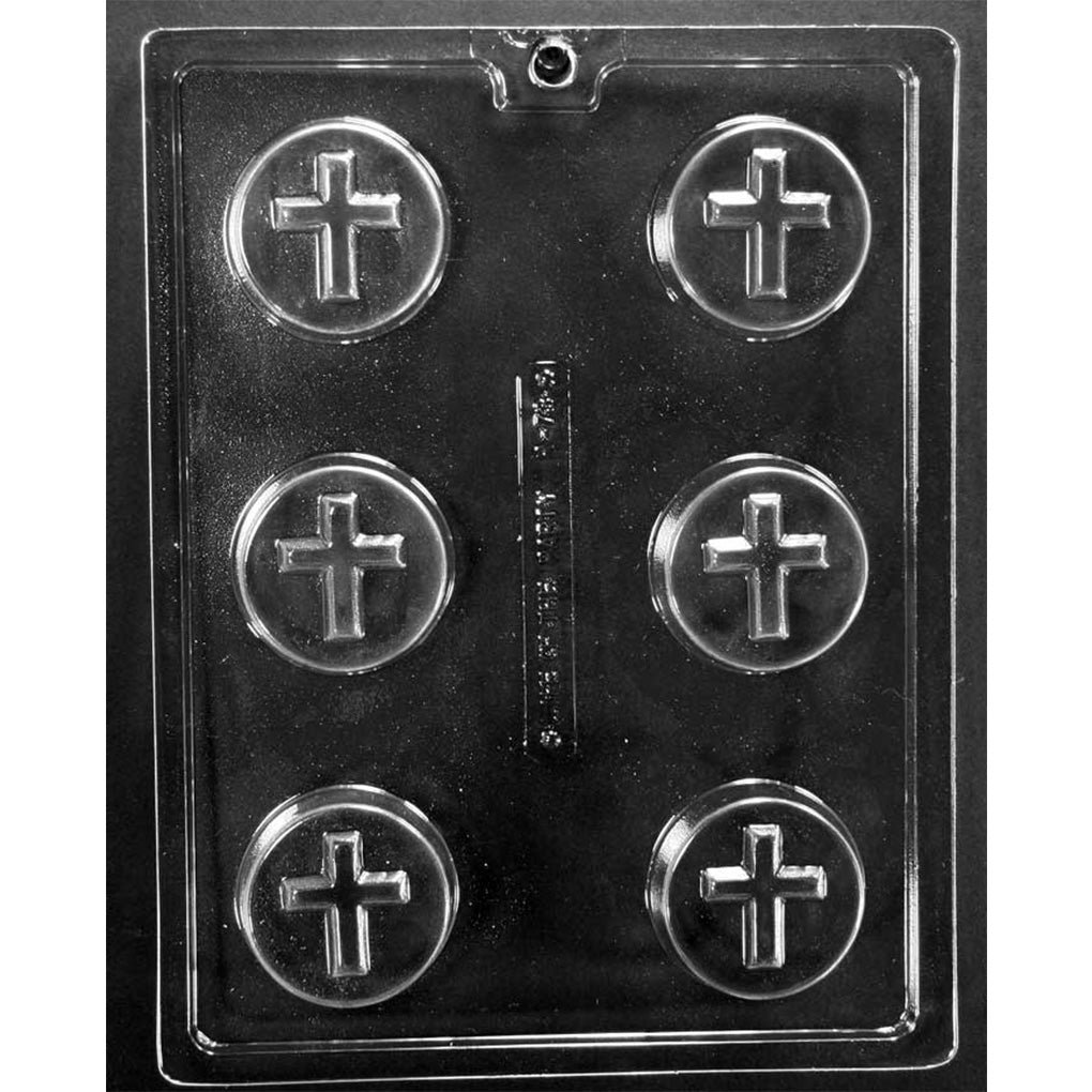 Clear plastic chocolate mold photographed on a black background with six round cavities, each featuring a centered smooth cross design within a circular rim.