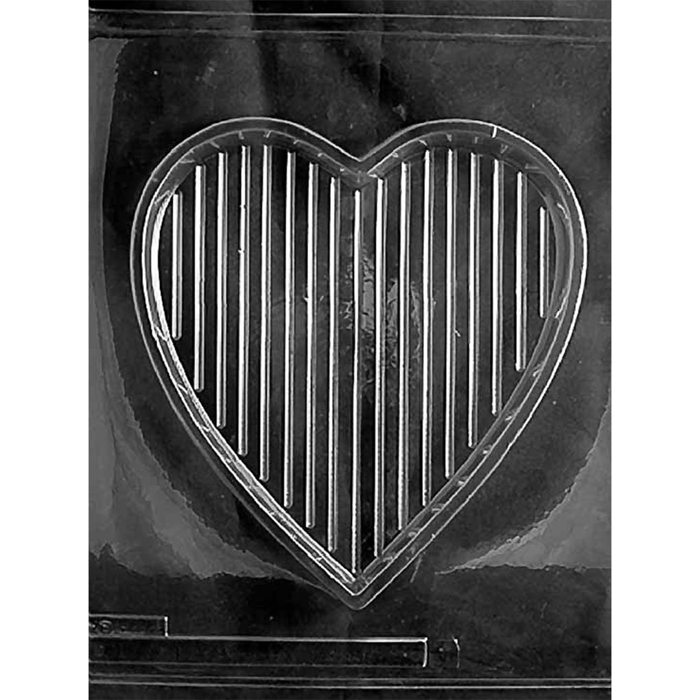 Clear plastic chocolate mold photographed against a black background featuring a deep, plain heart-shaped cavity that forms the bottom of a chocolate pour box.