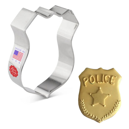 Badge cookie cutter next to a decorated gold cookie with "POLICE" embossed on the surface.