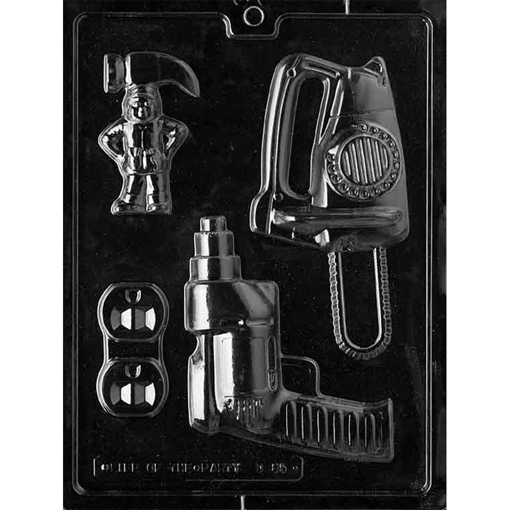 Clear plastic chocolate mold with a large circular saw cavity, a cordless drill cavity, a small hard hat figure cavity, and two mini dumbbell cavities arranged on one tray.