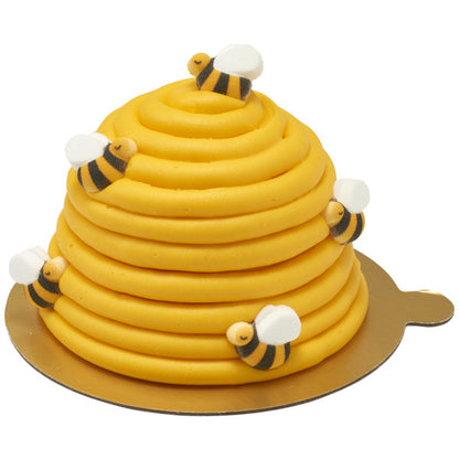 Beehive-shaped cake decorated with multiple bumble bee sugar toppers