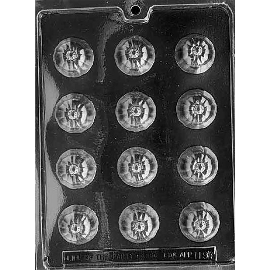 Clear Pumpkin Bon Bon Chocolate Mold photographed against a black background with 12 round pumpkin cavities featuring ridged sides and stem details.