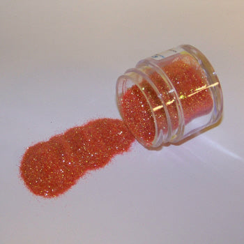 Orange-red Galaxy Glitter Dust spilled from a clear jar, glowing with fiery sparkle and subtle golden undertones.