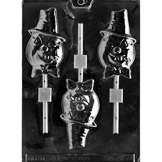 Clear Pumpkin with Cigar Chocolate Mold photographed against a black background with three lollipop cavities shaped like jack-o’-lantern characters wearing hats and bow ties, each holding a cigar.