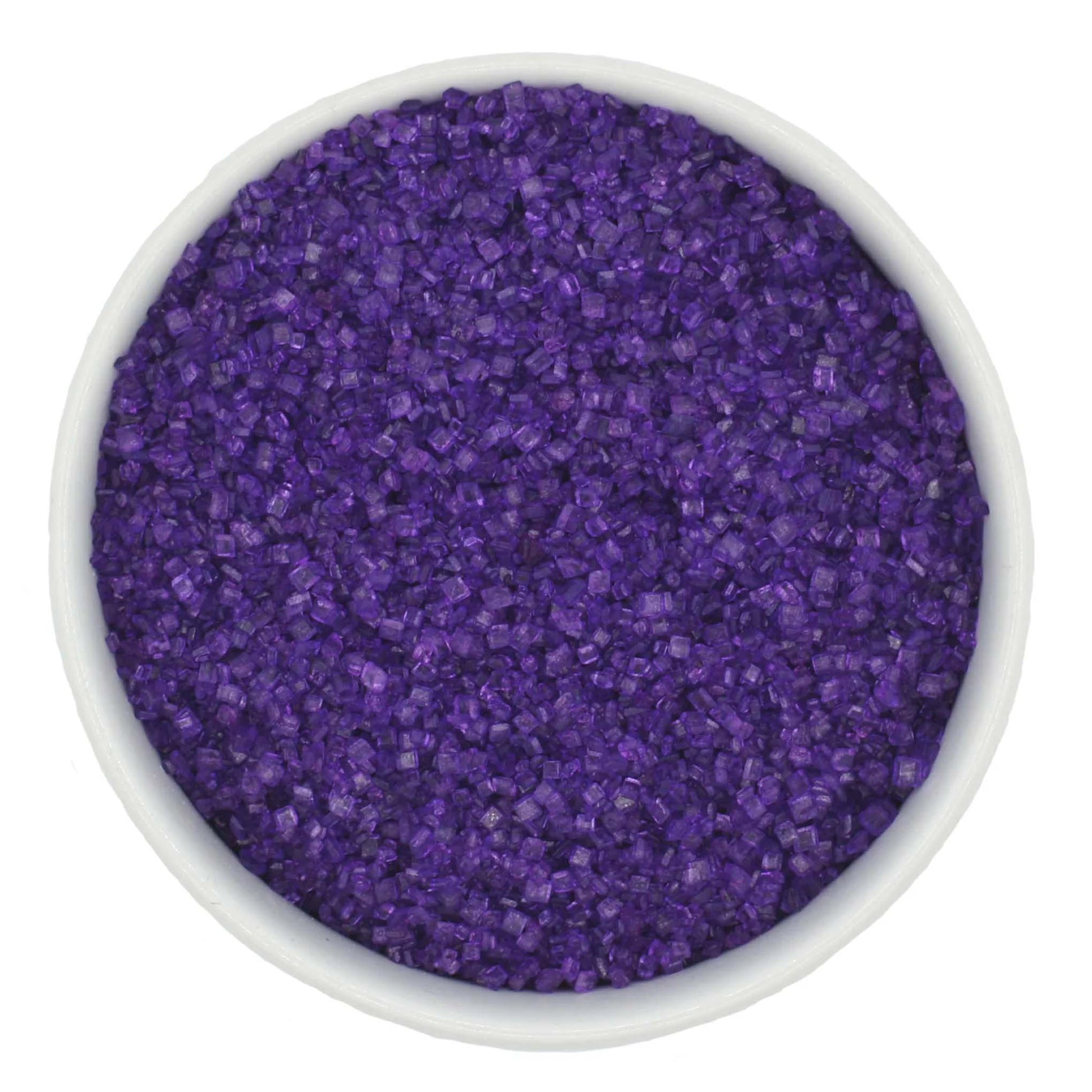 Top-down view of a white bowl filled with deep purple coarse sanding sugar crystals, showing chunky sparkling granules and a saturated violet color.