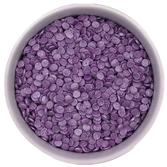 White bowl filled with small, flat, round Purple Pearlized Confetti Quinn Sprinkles showing their pearly finish