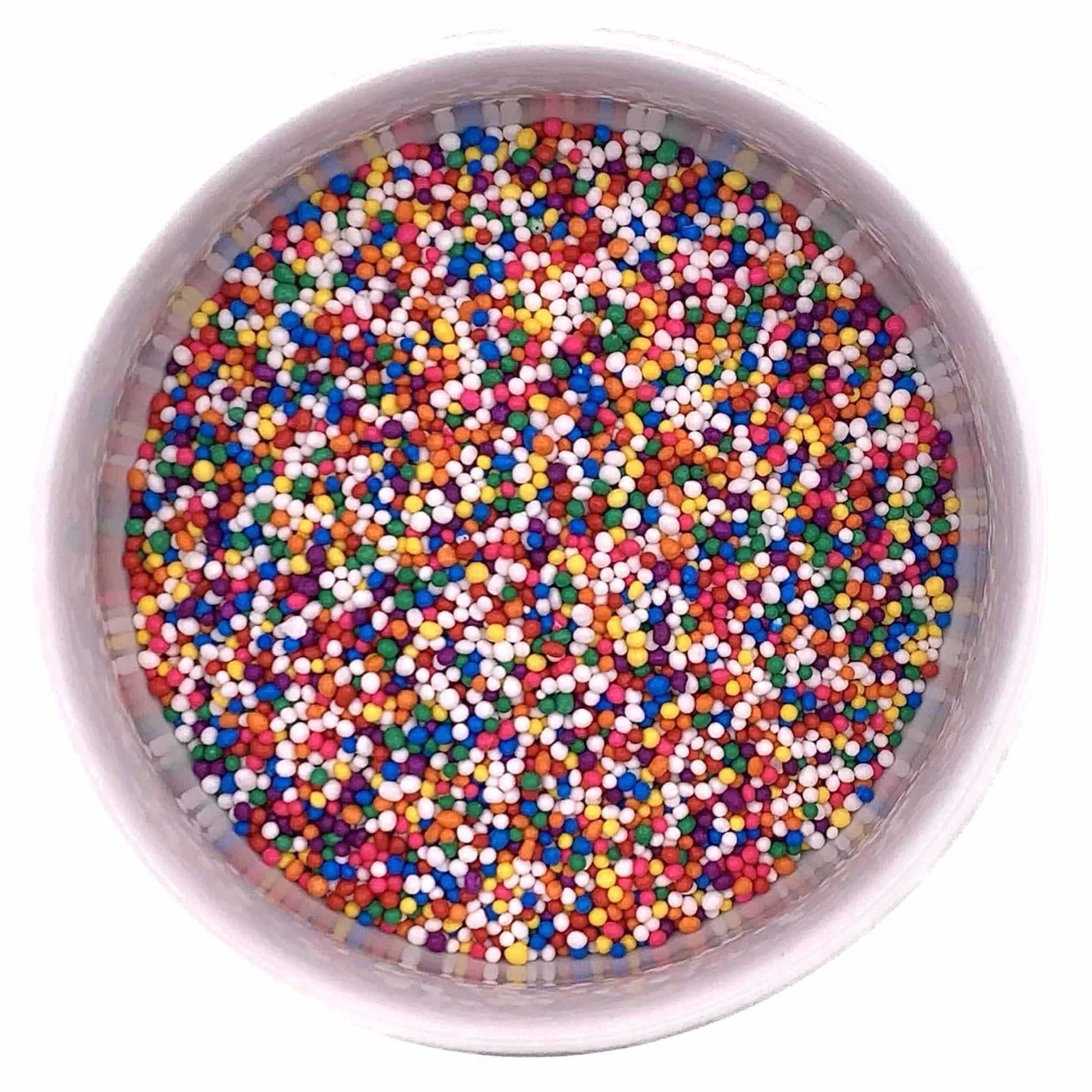 Top-down view of rainbow nonpareil sprinkles in a round container, showing multicolored tiny sugar beads