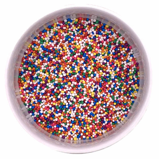 Top-down view of rainbow nonpareil sprinkles in a round container, showing multicolored tiny sugar beads