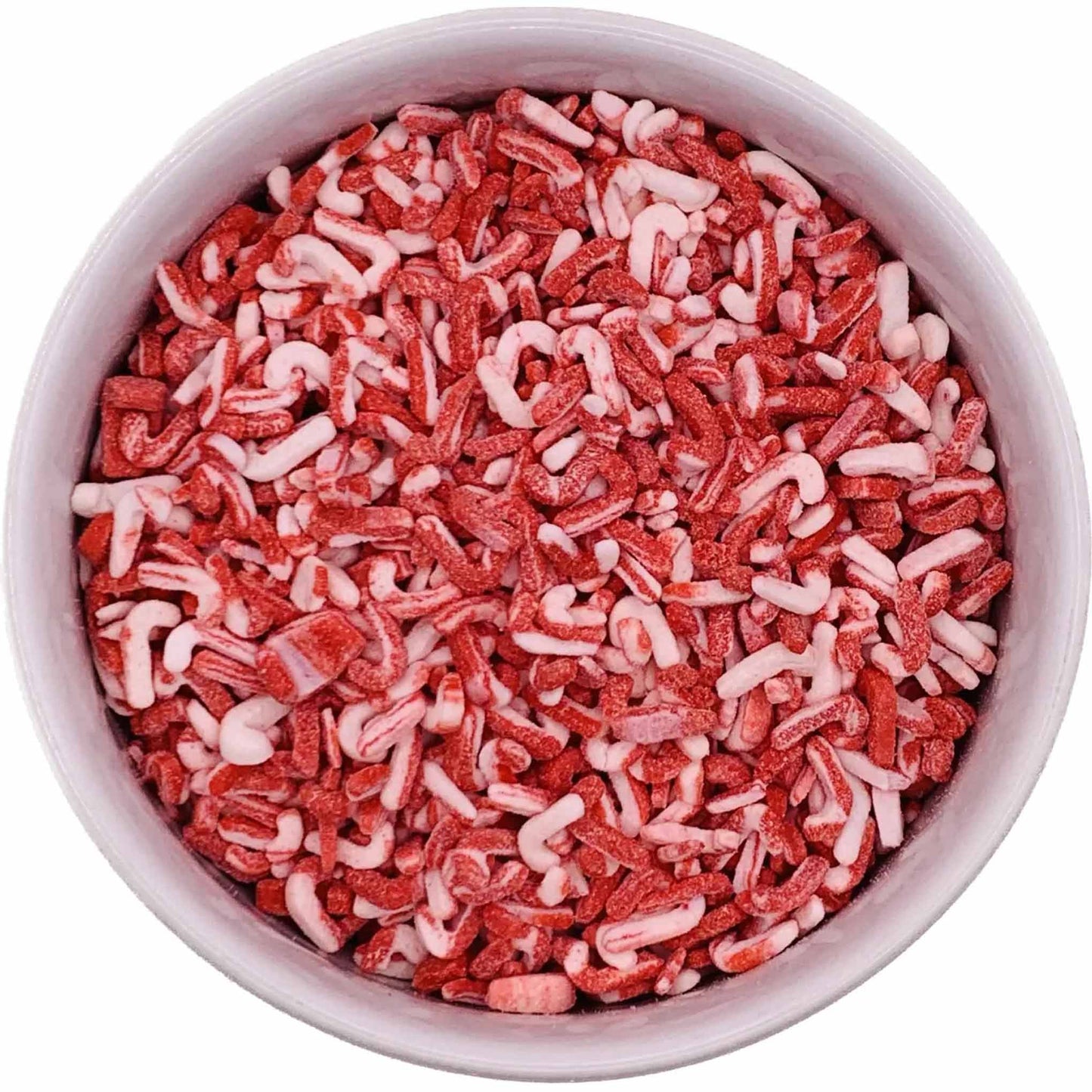 Top-down view of a round container filled with red and white candy cane–shaped sprinkles, showing a textured mix of crushed peppermint candy pieces