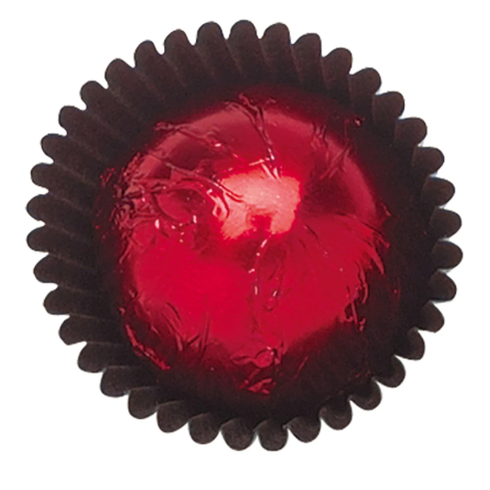 Close-up of a red foil-wrapped chocolate in a dark brown paper candy cup, showing glossy red metallic foil with crinkled texture.