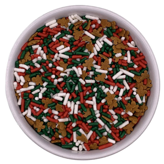 Bowl of red, green, and white jimmies sprinkle mix with gingerbread men shapes on a white background.