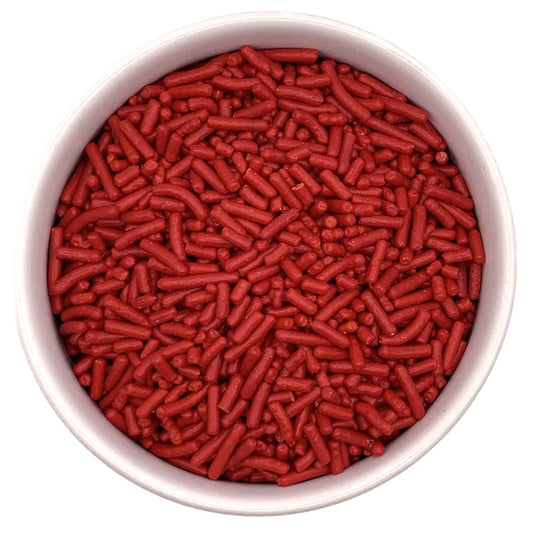 Top-down view of a round container filled with red jimmies sprinkles, showing small cylindrical red candy pieces packed closely together.