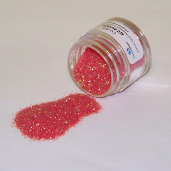 Jar labeled “Red Rainbow” tipped over, spilling vibrant red Galaxy Glitter Dust with gold shimmer onto a white surface.