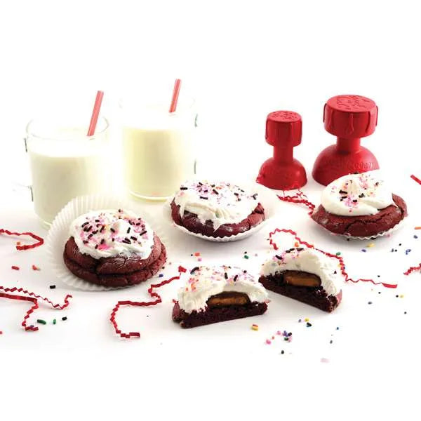 Red tampers with decorated cookies and two glasses of milk.