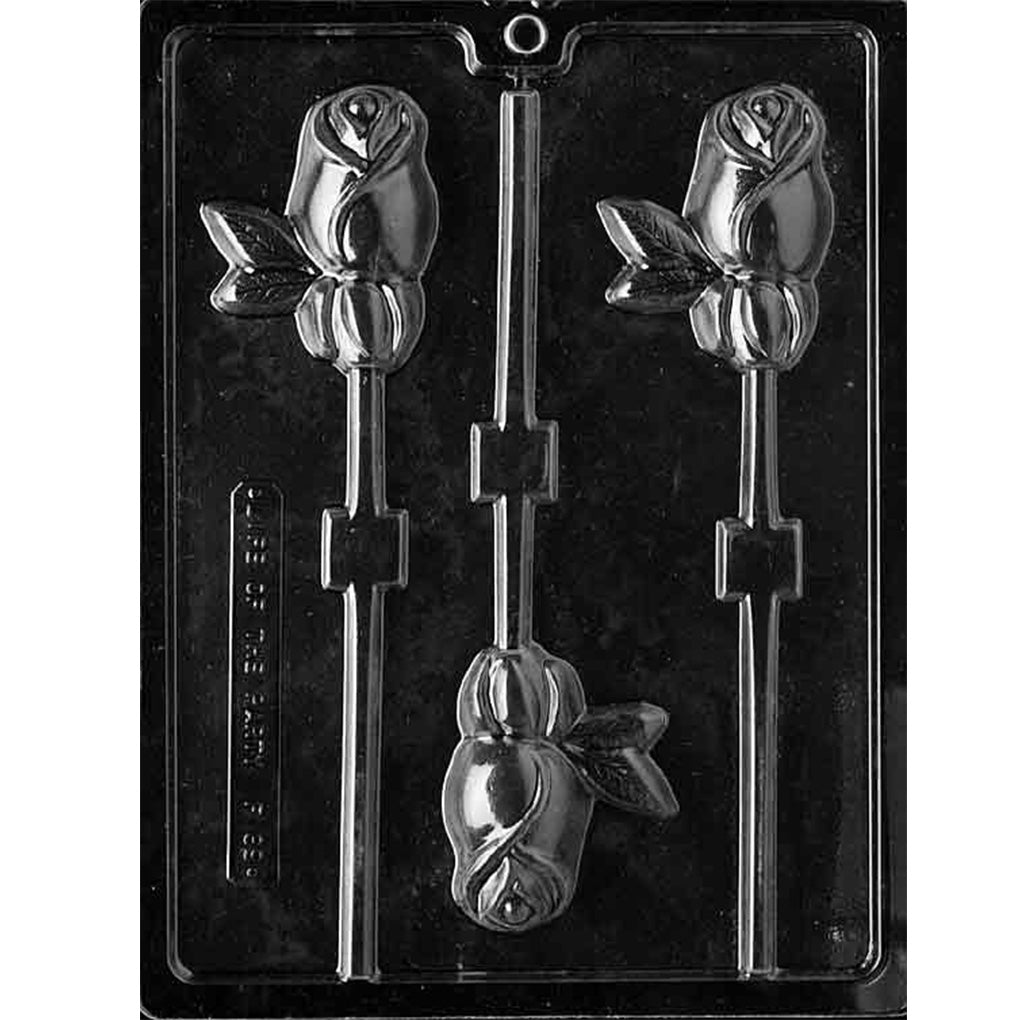 Clear plastic chocolate lollipop mold photographed on a black background with three rosebud-shaped cavities, each showing a rose blossom with leaf accents and a stick channel.