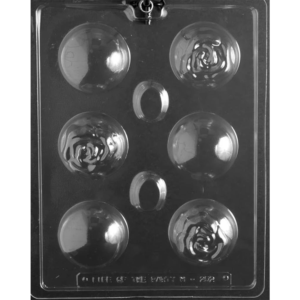 Clear plastic hot chocolate bomb mold photographed on a dark background with six half-sphere cavities, alternating smooth domes and domes embossed with a rose flower.