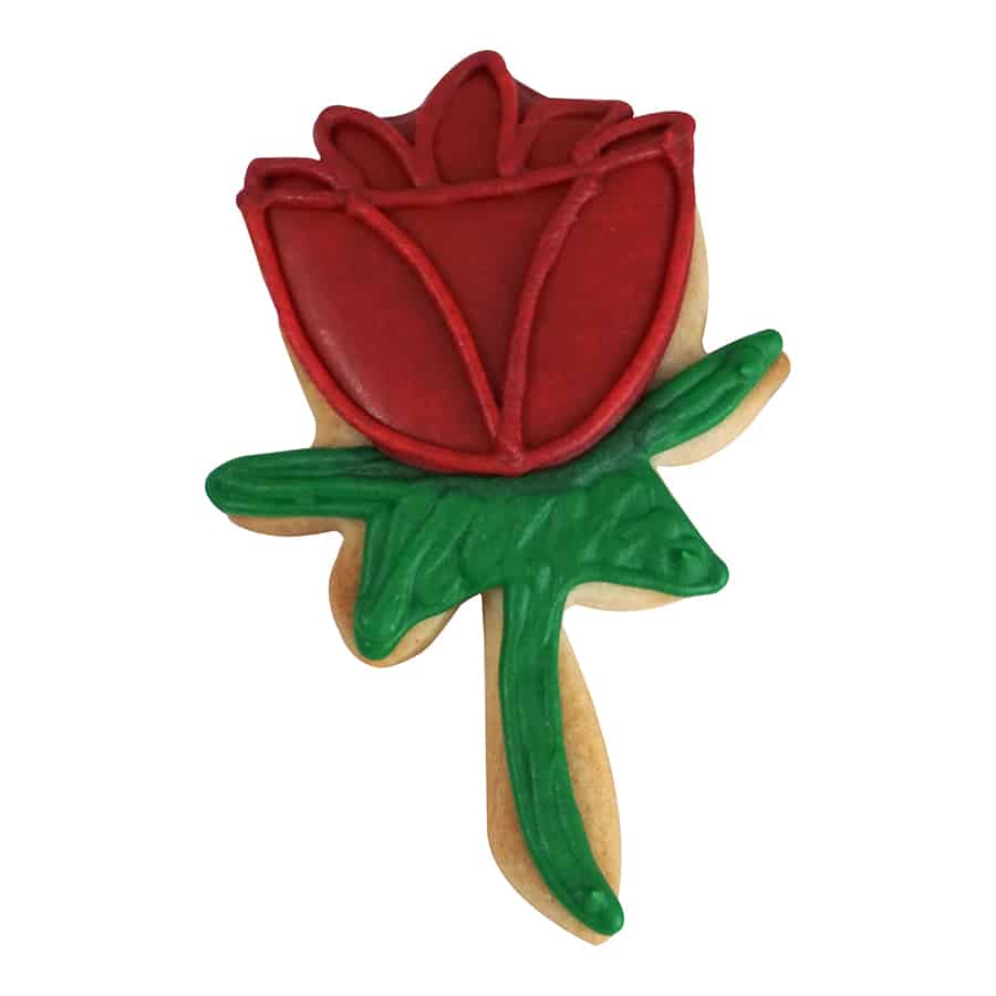 Decorated rose-shaped cookie with red petals and green leaves, created using a steel cookie cutter.