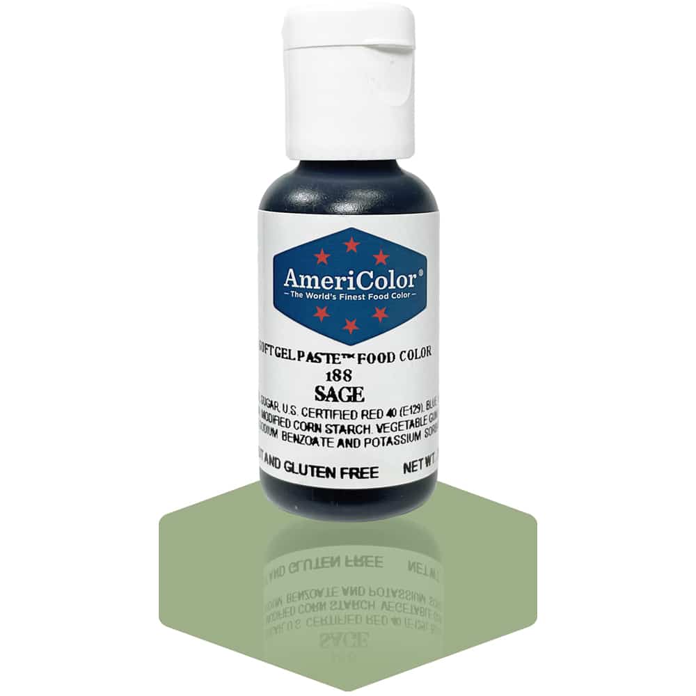 A bottle of AmeriColor Sage soft gel paste food coloring with a white cap, blue label, and red stars, positioned on a sage green reflective surface with the bottle’s reflection clearly visible.