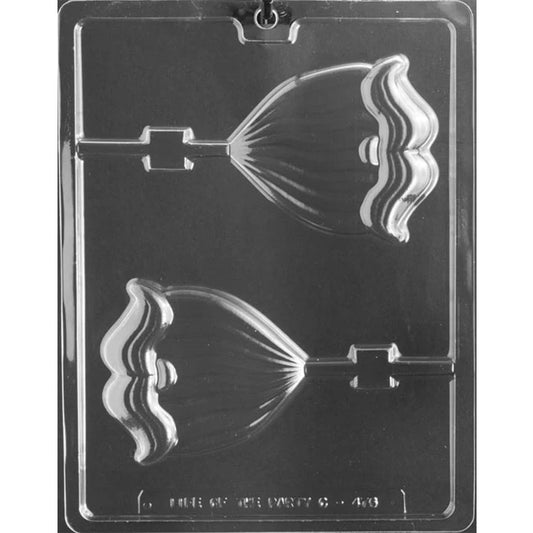 Clear plastic chocolate lollipop mold photographed on a dark background with two Santa beard cavities, each showing scalloped beard waves, a moustache detail, and a lollipop stick channel.