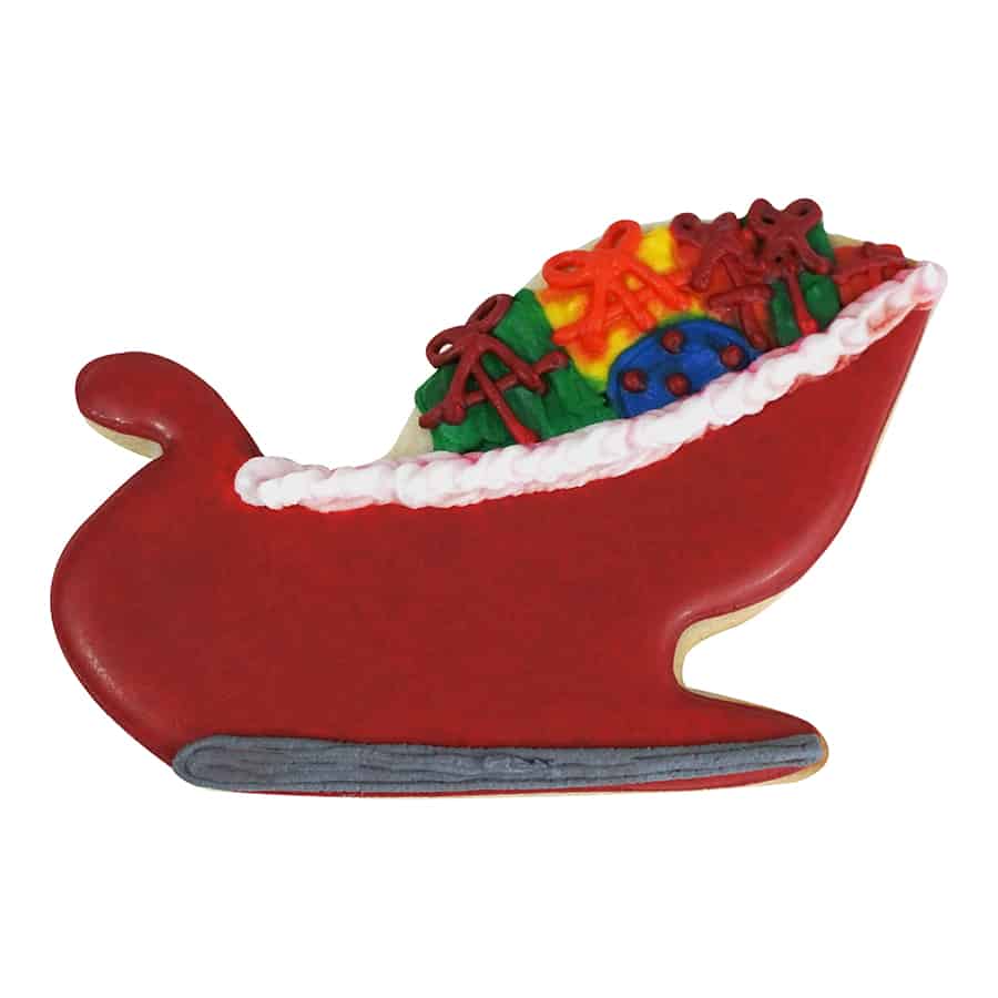 Santa's sleigh-shaped cookie decorated with red icing, a white trim, and colorful presents stacked inside.