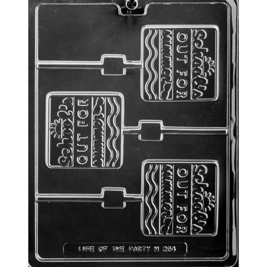 Clear plastic chocolate lollipop mold with three square cavities embossed “School’s Out for Summer” with decorative border patterns and stick channels, shown on a dark background.