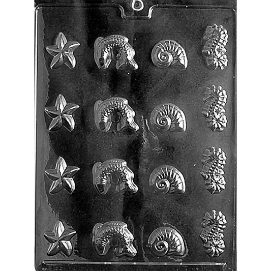 Clear plastic chocolate mold with assorted sea-themed cavities in rows, including starfish shapes, leaping fish, spiral shells, and detailed seahorses on a dark background.