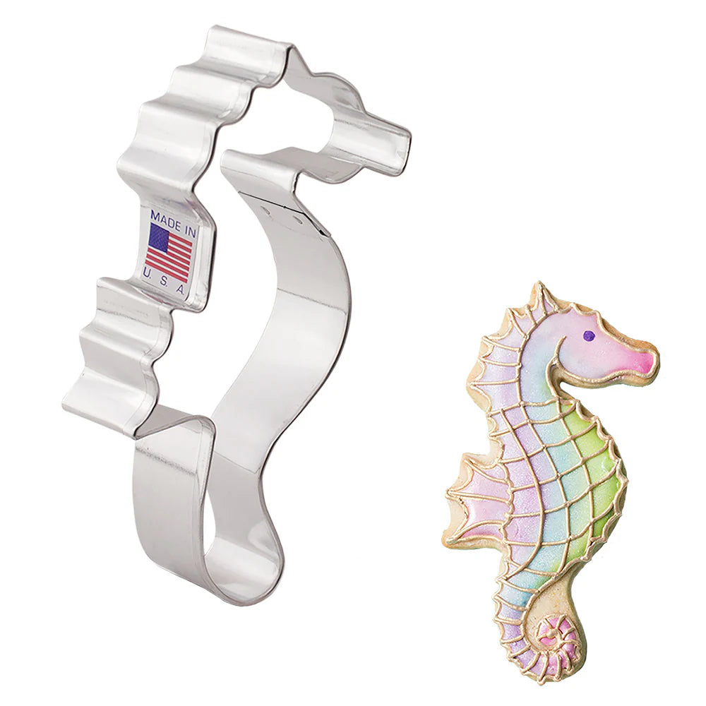 Seahorse Cookie Cutter displayed alongside a decorated seahorse-shaped cookie with pastel iridescent icing and gold accents.