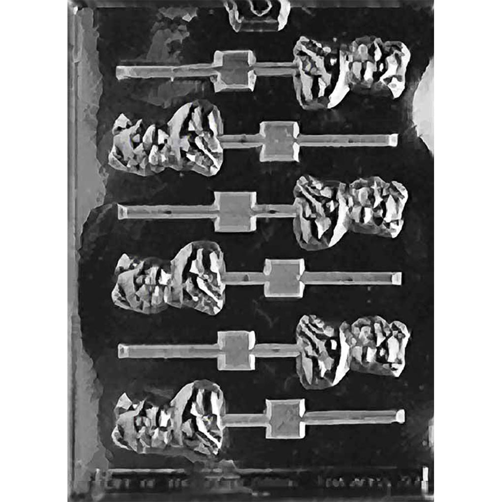Clear chocolate lollipop mold with six pig-shaped cavities arranged in two columns on a dark background.