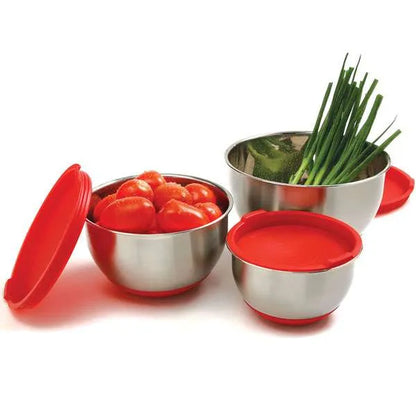 Three stainless steel mixing bowls with red lids, filled with fresh produce including tomatoes and green onions, highlighting the bowls’ storage and stacking capabilities.