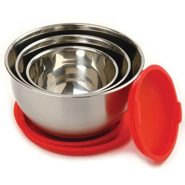 Three nested stainless steel mixing bowls with one red lid off to the side, showcasing the polished interior and stackable design