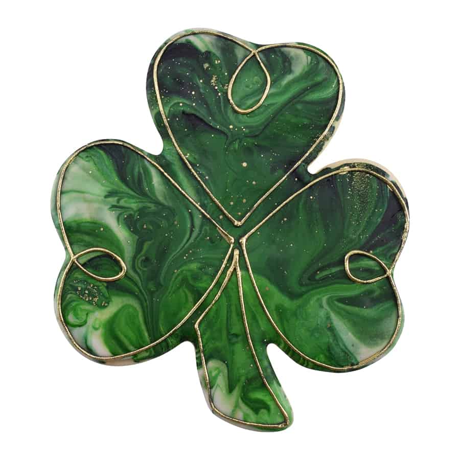 Decorated shamrock-shaped cookie with a green marbled icing and gold piping details.