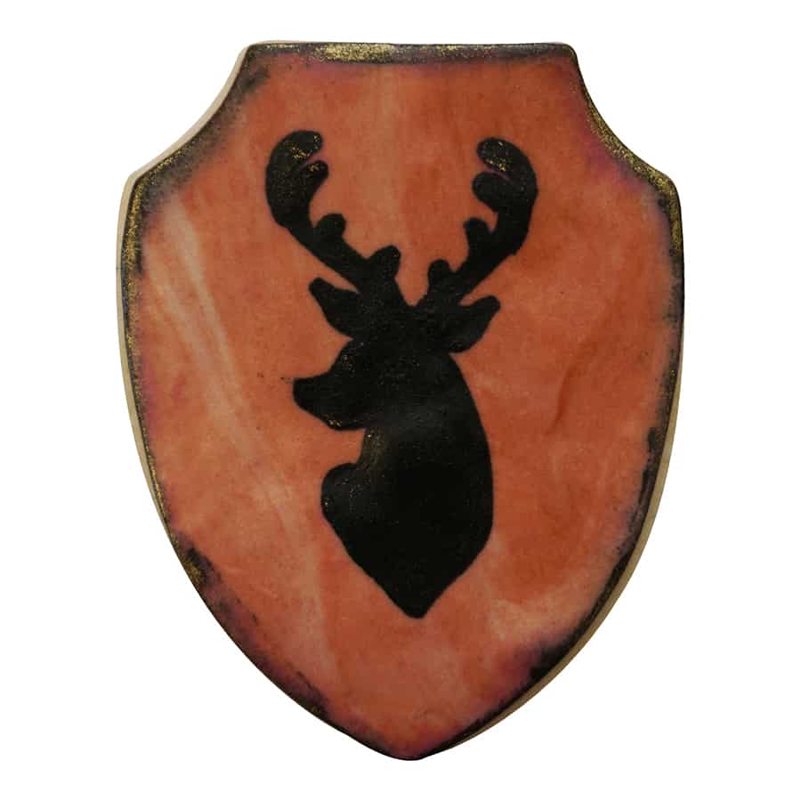 Decorated cookie with a shield design, featuring a black silhouette of a deer on a marbled background.