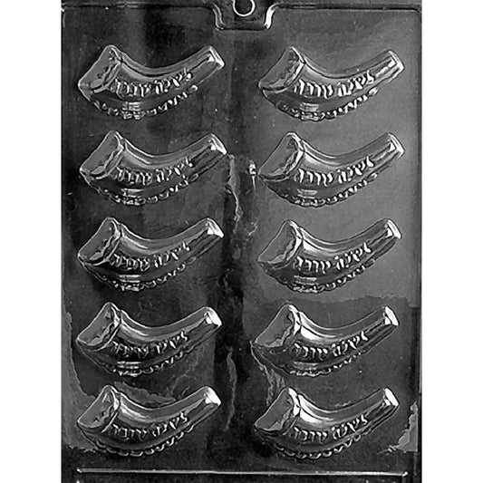 Clear plastic chocolate mold photographed on a black background with multiple curved shofar horn cavities in rows, each with a tapered tip and raised detail along the horn.