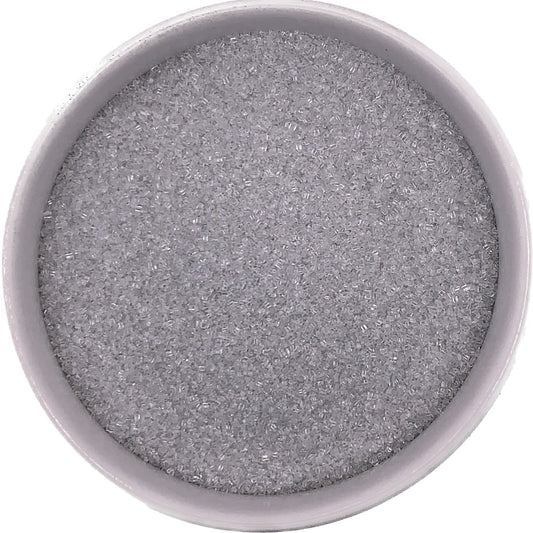 Fine silver sanding sugar in a white bowl, metallic shimmer crystals ideal for winter and celebration themes.