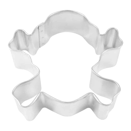 Skull and crossbones-shaped cookie cutter with a wavy bone outline, photographed from a top-down angle.