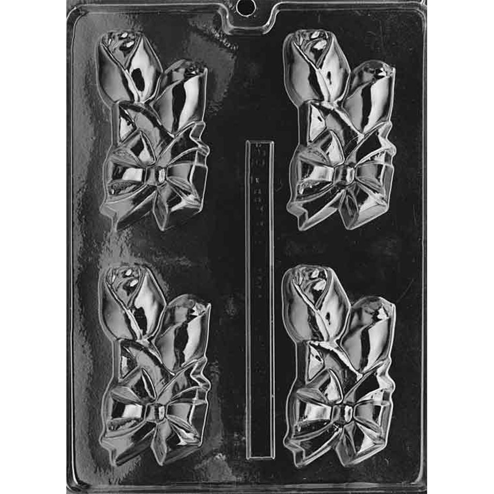 Clear chocolate mold with four corsage-shaped cavities featuring two rosebuds tied together with a large ribbon bow.