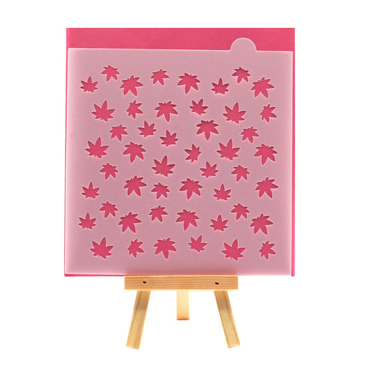 Small marijuana leaf pattern cookie stencil on a pink background, shown on a small wooden easel.