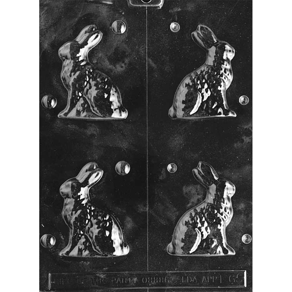 Clear plastic chocolate mold with a vertical center cut line and four cavities showing a small sitting bunny in side profile with upright ears and textured fur detail, on a dark background.