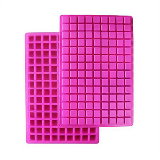 Bright pink square silicone mold sheets with small square cavities, stacked and overlapping on a white background.