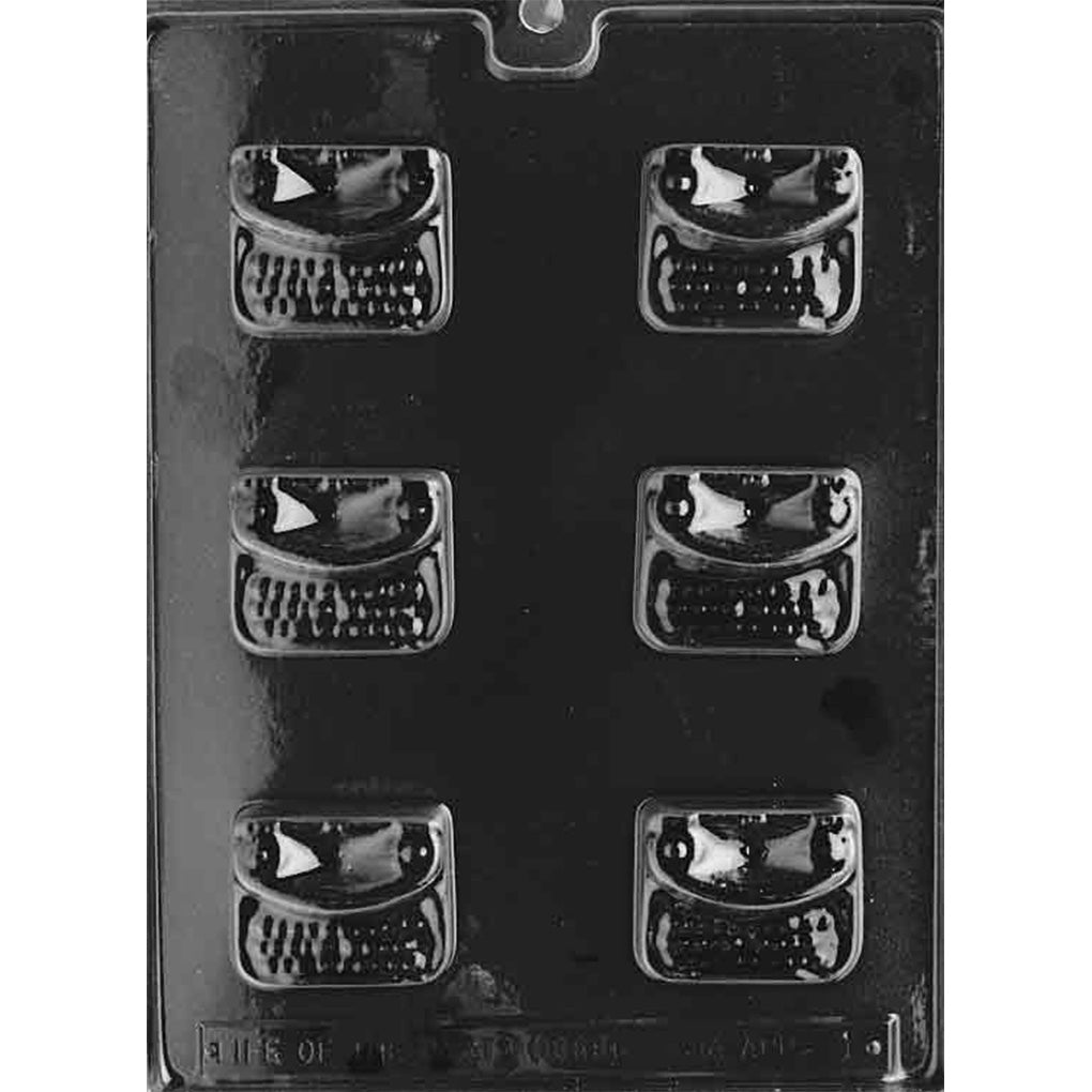 Clear chocolate mold with six miniature vintage typewriter cavities featuring raised paper sections, rows of tiny keyboard keys, and rounded rectangular bodies.