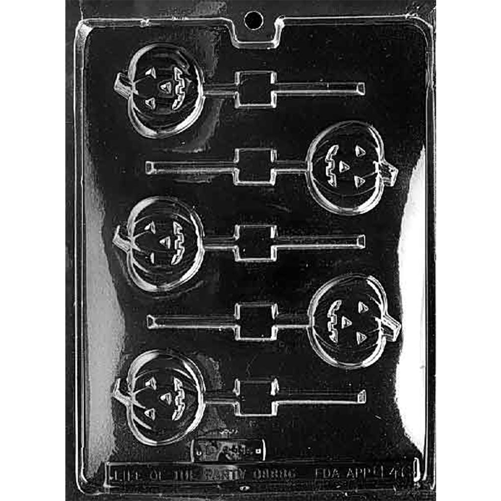 Clear plastic chocolate lollipop mold with multiple round jack-o’-lantern pumpkin cavities featuring triangle eyes and a carved smile, with stick channels; shown on a dark background.