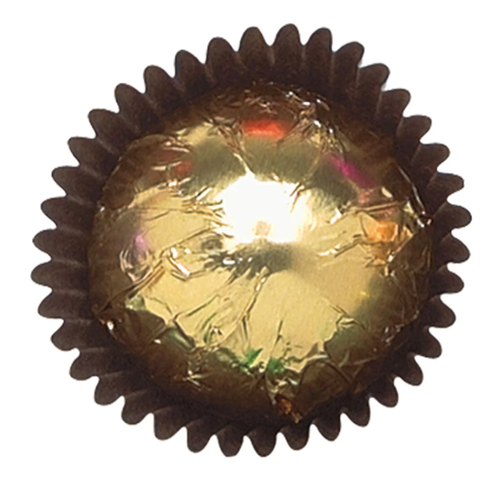 Close-up of a gold foil-wrapped chocolate in a dark brown paper candy cup, showing reflective metallic foil with light creases.