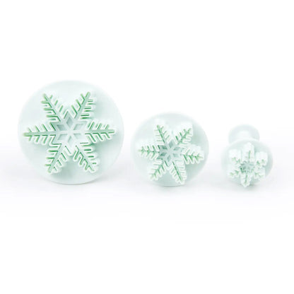 Three-piece snowflake plunger cutter set in graduated sizes, ideal for fondant, gum paste, and holiday cookie decorating.